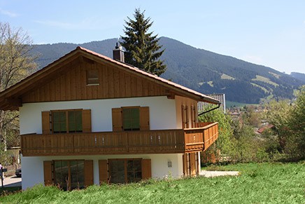 Haus Schwänli mit Holzfassade vor den Bergen
